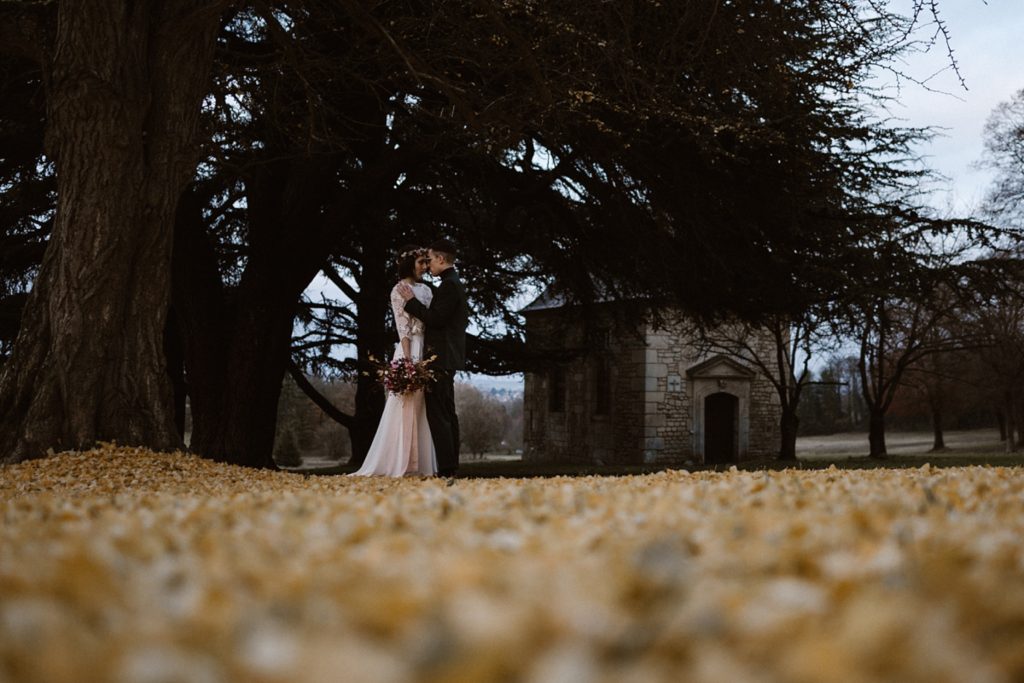 Mariage Moody photo de couple en hiver sur tapis de feuilles jaune